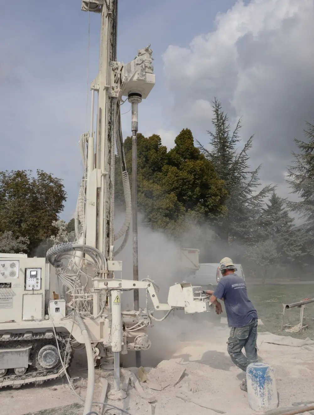 Borehole drilling rig with drill rod boring into the ground